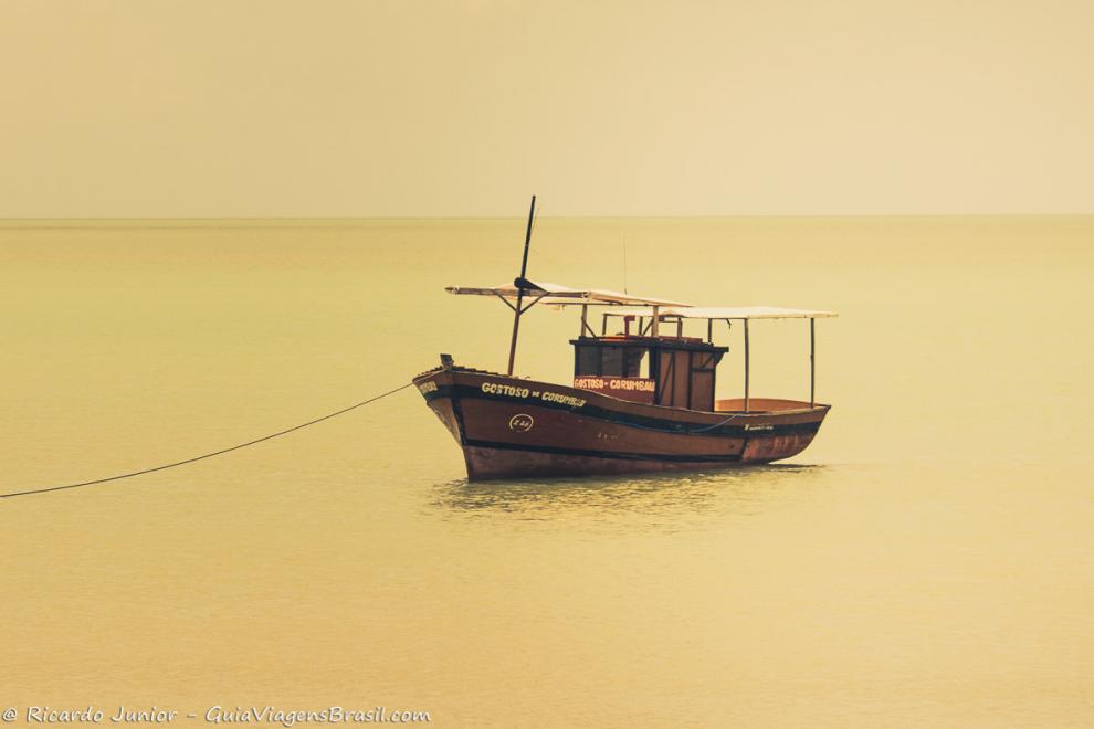 Imagem de um barco no mar da Praia de Corumbau.